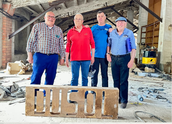 Former factory workers with the DUSOL sign made by Vicenç